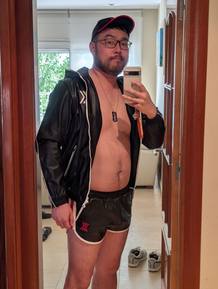 mirror pic of me wearing newly a purchased red-and-black cap, white-and-black jacket and red-white-and-black leather shorts, with the logo X of the brand Boxer visible.  Also wearing a Laird Melbourne dog tag