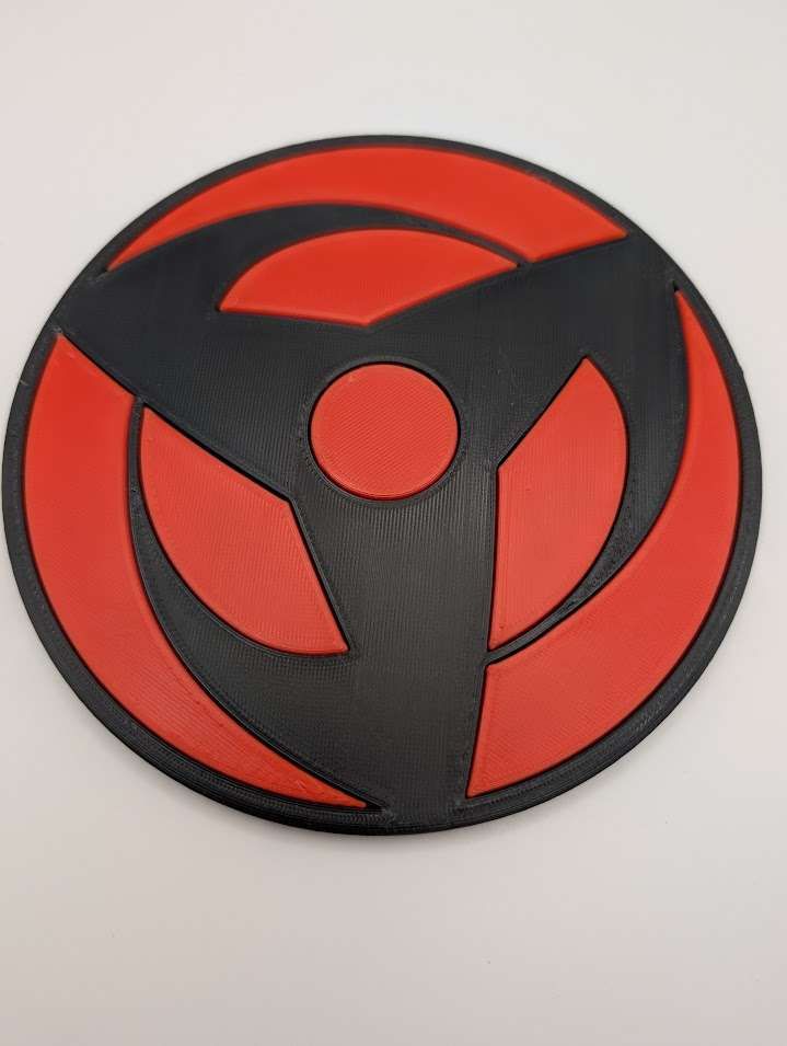 Red and black swirling pattern of three fan like blades looking like they are in motion with connecting black rings.