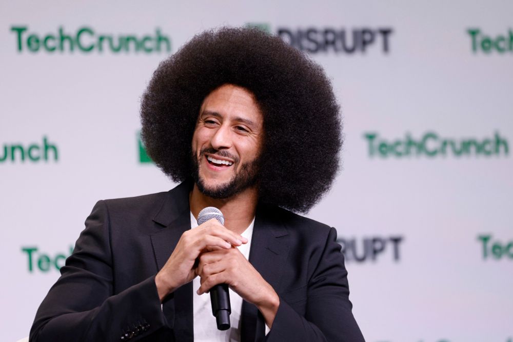 A tight shot of Colin Kaepernick holding a microphone onstage at TechCrunch Disrupt. 