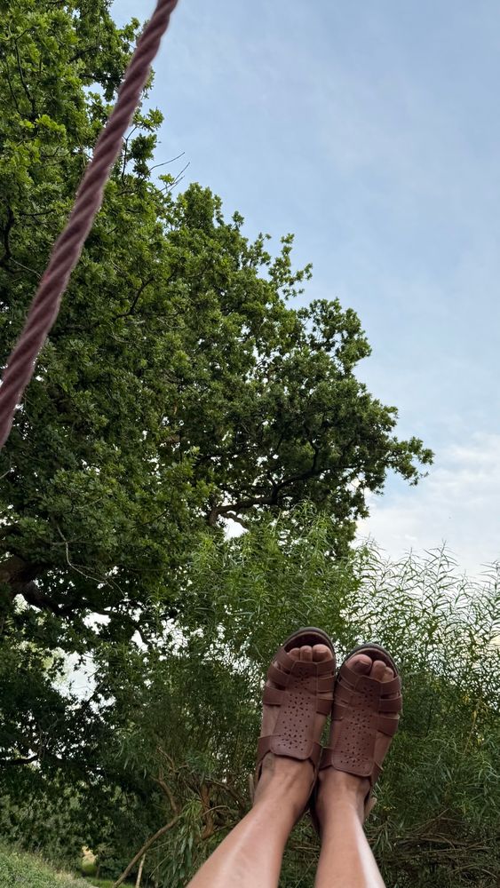 A selfie on the swing showing my feet in the air with trees beyond!