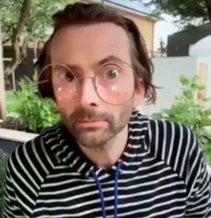 David Tennant in a black and white striped hoodie, with an Instagram filter applied which looks like very large glasses 