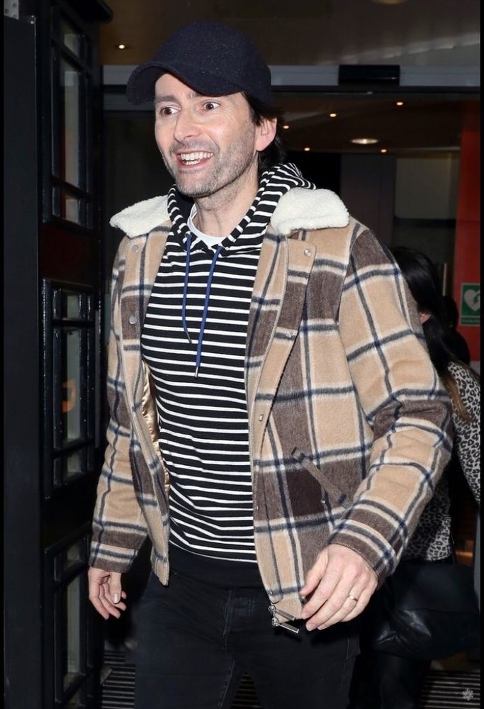 David Tennant outfit repeater, wearing a black and white striped hoodie, a navy baseball cap, and brown check jacket.