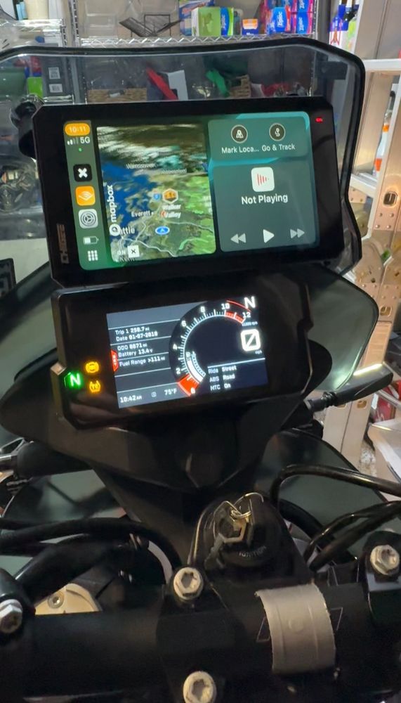 Cockpit of the ktm motorcycle with main control panel below and new large screen GPS unit above.