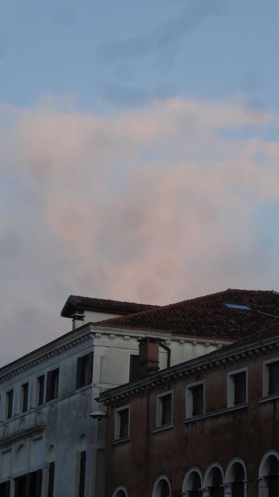 Corner of an old roof with sunset clouds in the background