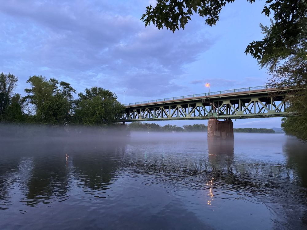 Evening photo of the Connecticut River and the Calvin Coolidge Memorial Bridge enveloped in a light low fog