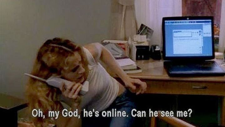 A blonde woman at a desk with her laptop, huddled away from the computer while on the phone. 

Captioned "Oh, my God, he's online. Can he see me?" 