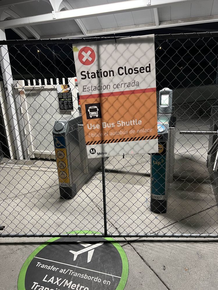 A fence erected around the entrance to a Los Angeles MTA Metro rail station. A sign states that the station is closed and suggests taking the bus instead.