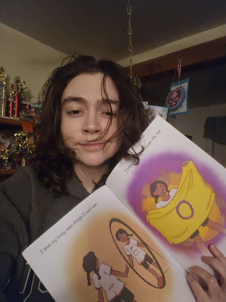 Killian Rose showing the inside of their book "I love my body"