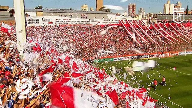 a crowd of people in a stadium with an ad for nissan