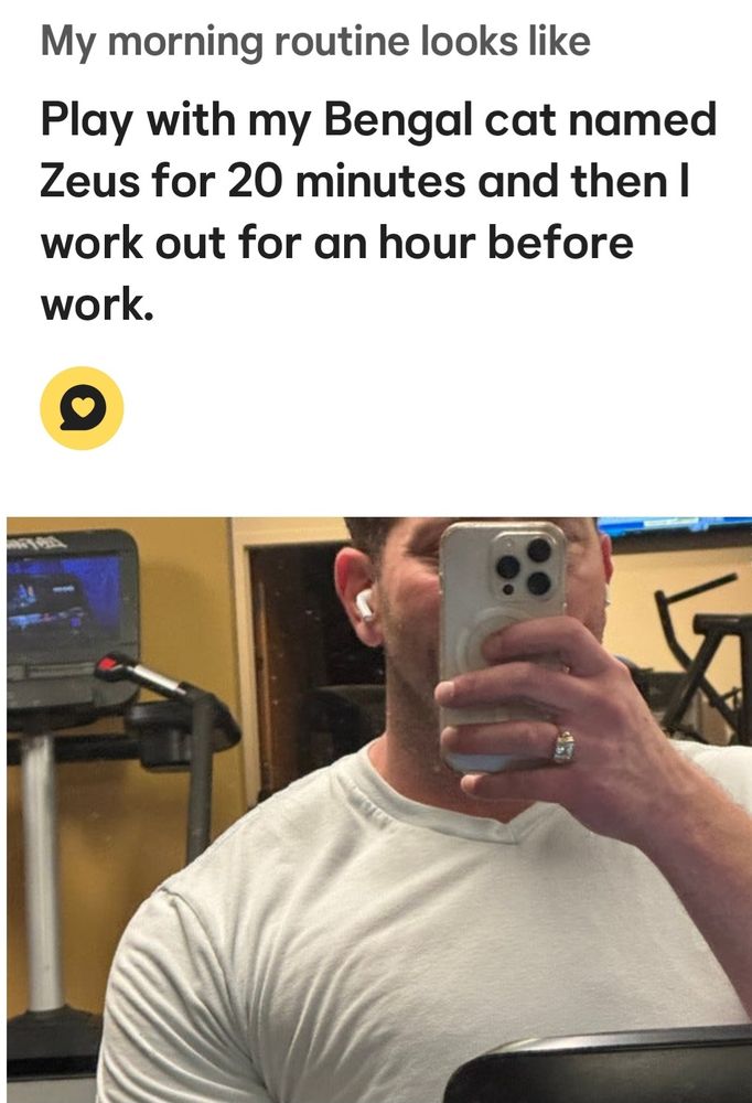Screenshot from a dating app. At the top it says: My morning routine looks like Play with my Bengal cat named Zeus for 20 minutes & then i work out for an hour before work Under that is a selfie of the man in question, with his phone in front of his face, clearly at the gym. He has a giant, gaudy, bejeweled wedding band on. He also has sausage fingers.