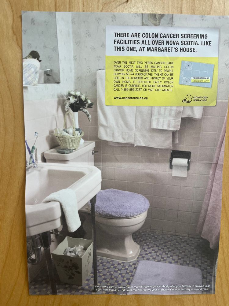 Image of a poster in a GP office. It is a picture of a bathroom with a toilet and sink, towels on a railing and a shower curtain. The text reads "There are colon cancer screening facilities all over Nova Scotia. Like this one, in Margaret's House. Over the next two years Cancer Care Nova Scotia will be mailing colon cancer home screening kits to people between 50-74 years of age. The kit can be used in the comfort and privacy of your own home. If detected early, colon cancer is curable. For more information call 1-866-599-2267 or visit our website - www.cancercare.nc.ca".