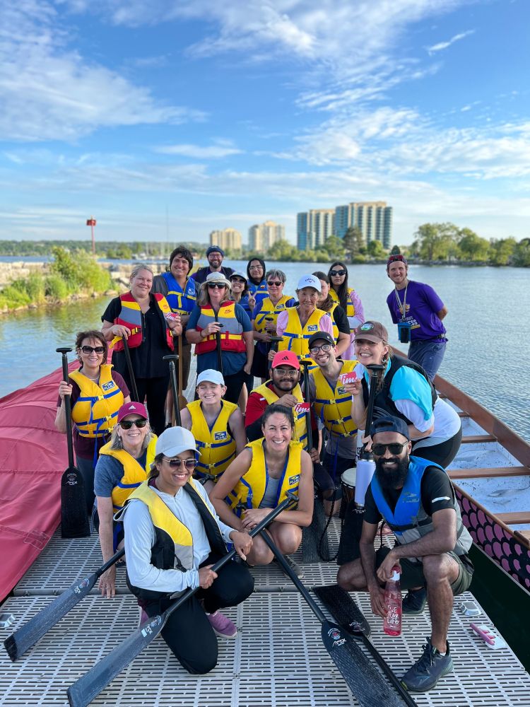 Group photo on the dock holding paddles