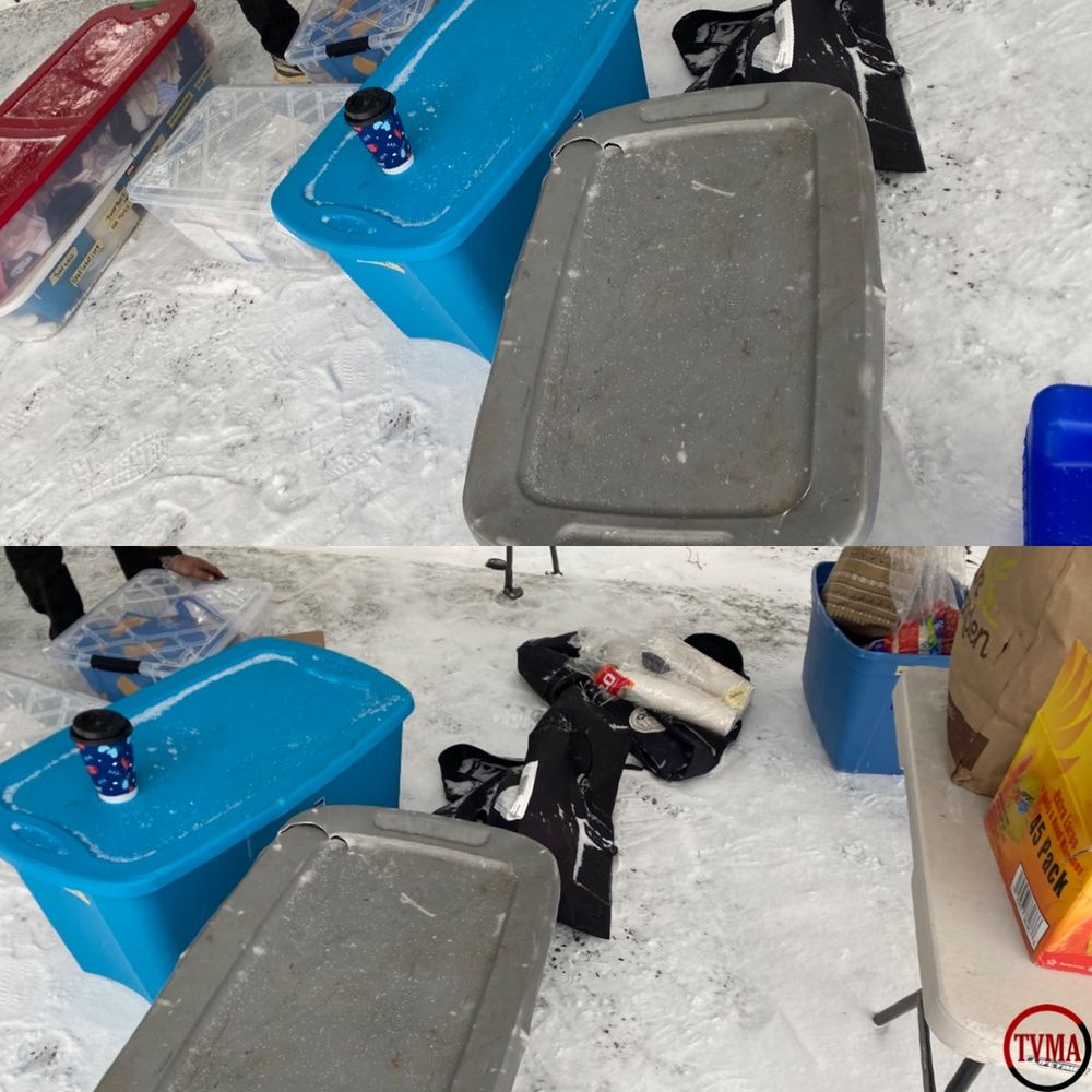 The image is split into two sections the top section shows on the snow covered ground: two tubs in the center full of clothes for masculine and feminine, to the left is two clear which has some cleaning supplies and bags. On the far left, the bottom clear tub is full of Hygiene products and menstrual products. The clear tub on top of the other one is full clothes

On the bottom right is a circle with “TVMA” written in the middle. The top of the circle is red and the bottom half is black.