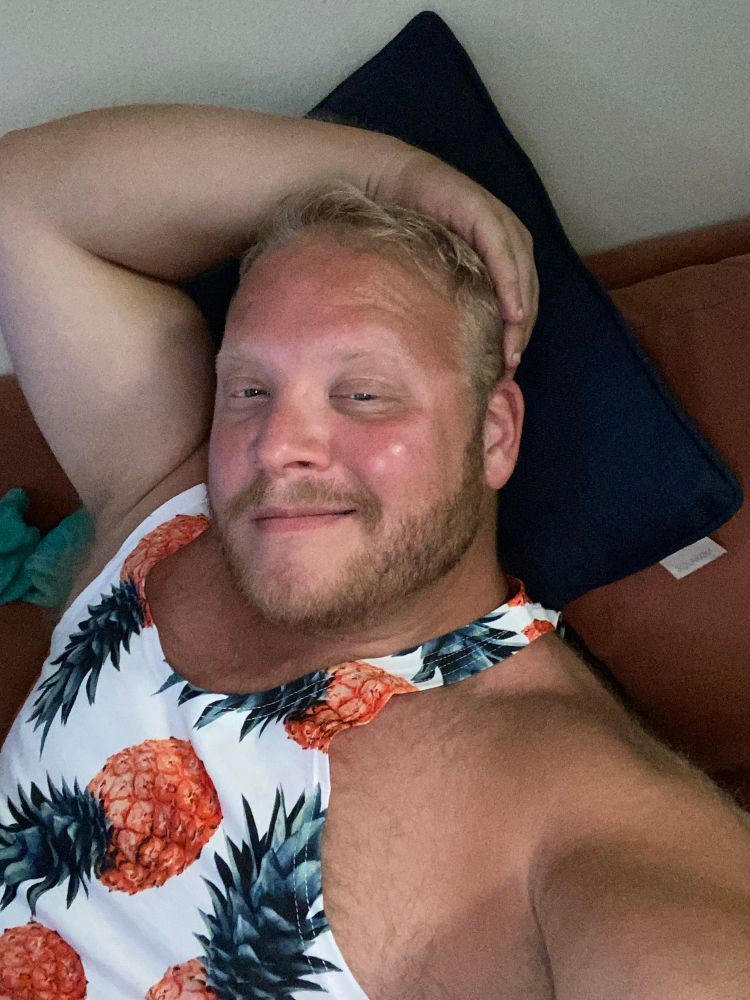 Man smiling for a selfie with one hand placed on top of his head