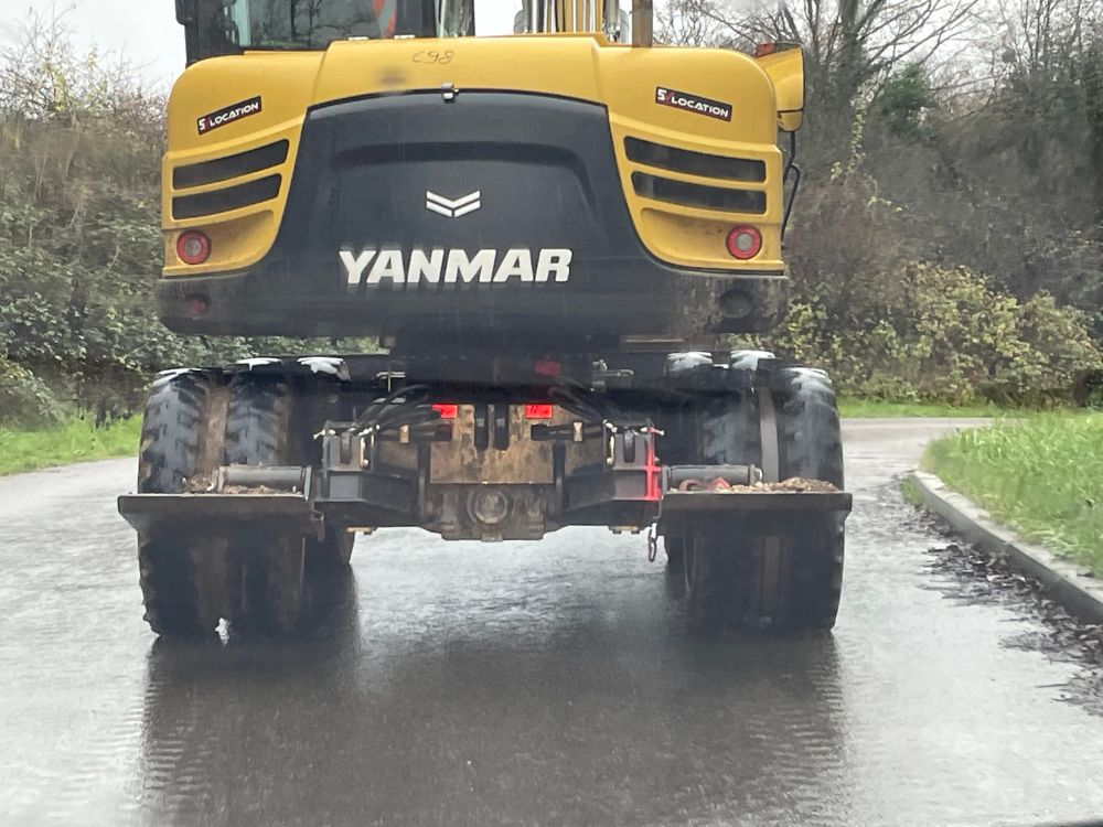 Photo de l’arrière d’une pelle mécanique sur la route, sur laquelle on peut lire « Yanmar ».