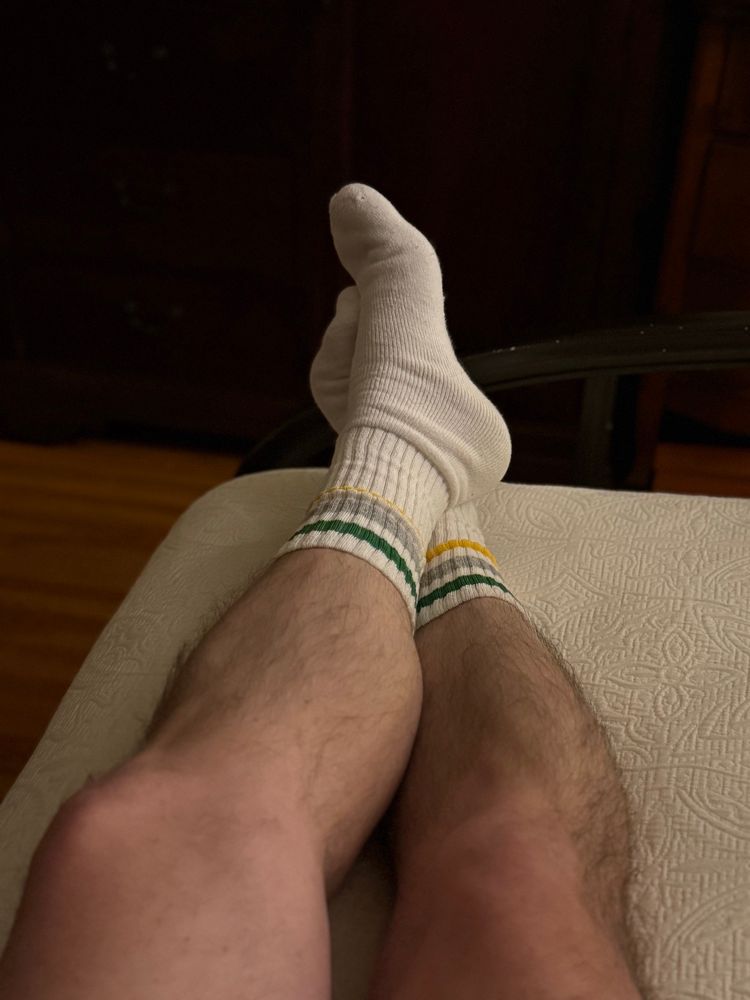 My hairy legs and white tube socks with green, grey and yellow stripes.