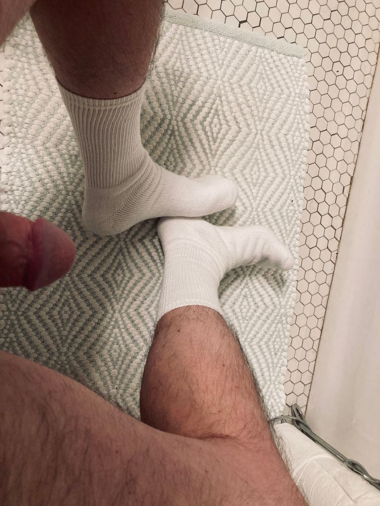 View from above of my white crew socks, hairy legs and a bit of my penis.