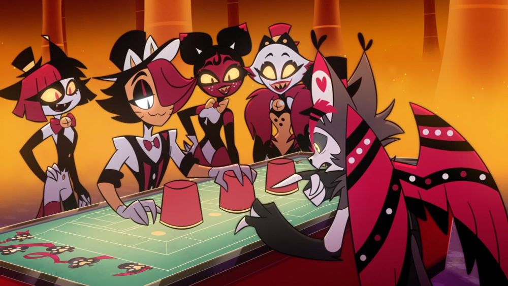 The dealer Huskette holds their hand on the middle cup face down. Three other smiling Huskettes stand beside the dealer. Husk stares hard at the middle cup and points at it.