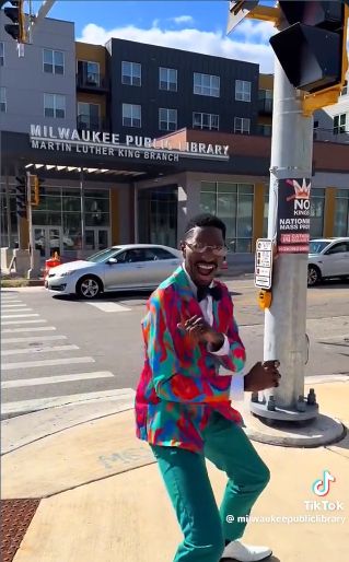 still from the video with the dancer at a crosswalk across from the library branch, a 