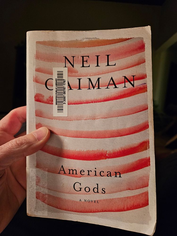 The paperback edition of the book "American Gods" by Neil Gaiman.