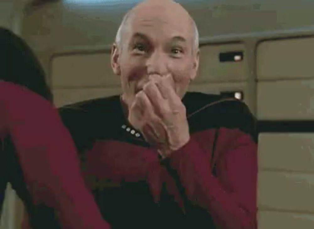 a man in a star trek uniform is making a funny face while sitting on a chair .