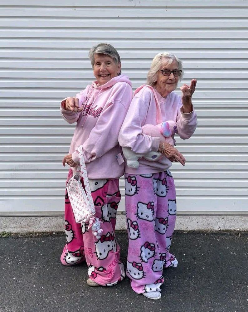 two older women, dressed in pink hoodies and pj pants 