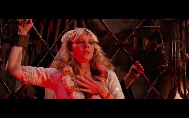 Wilie Scott in The Temple of Doom

She's wearing a white outfit and flowers as she holds her hand over her heart