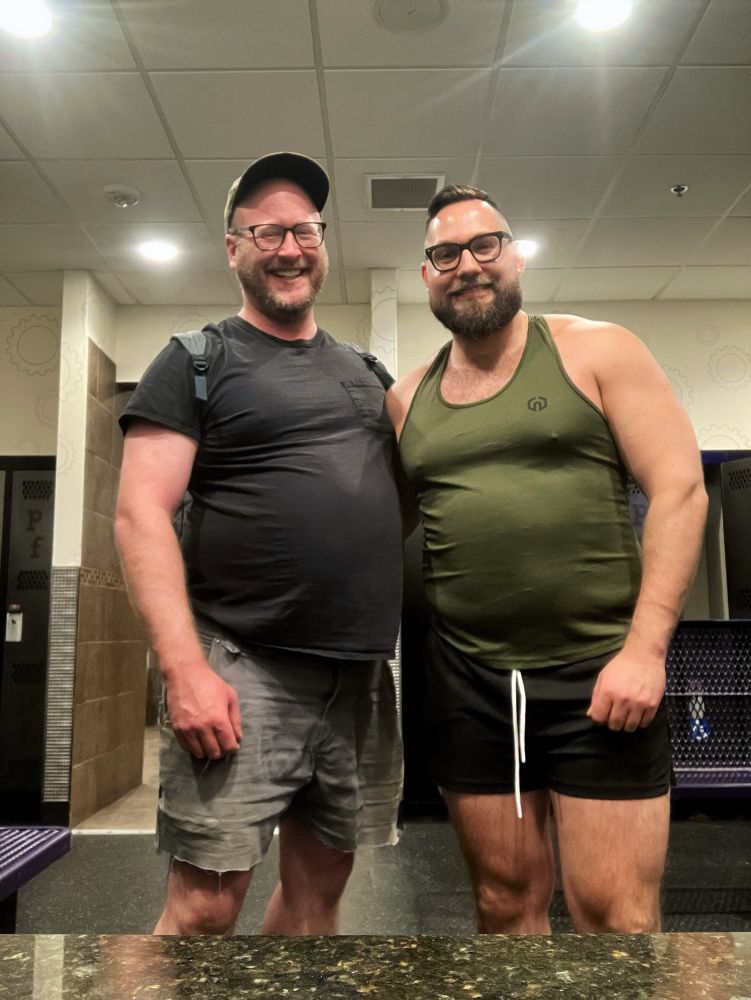 Two beefy muscle bears posing in the gym locker room after working out.