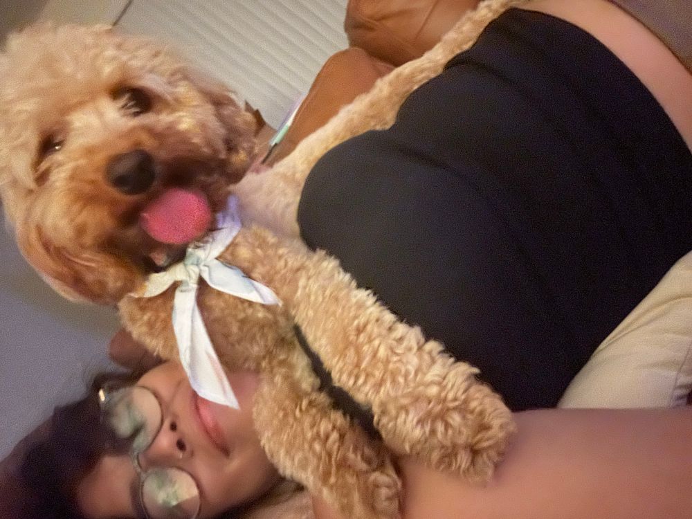 Blurry brown dog snuggling with Surena 