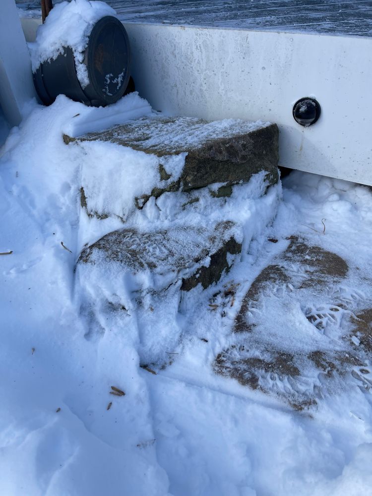 Snow covered Greenstone steps onto a deck.