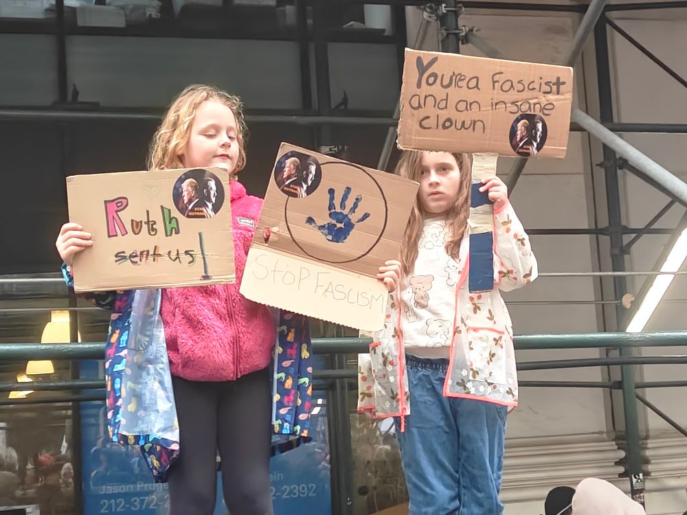 Two kids holding antifascist signs 