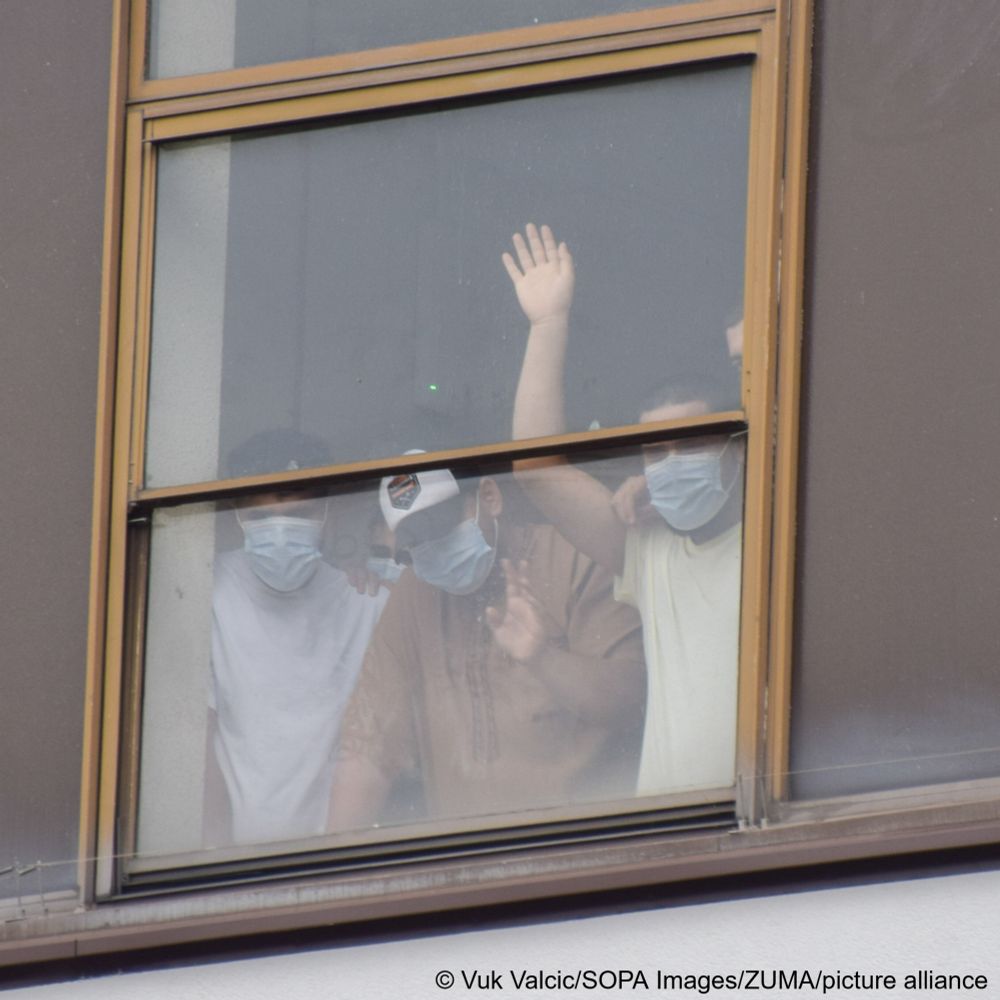 Migrants watch protesters from their rooms at the Thistle Hotel in London during demonstrations against and in support of migrants over the weekend.