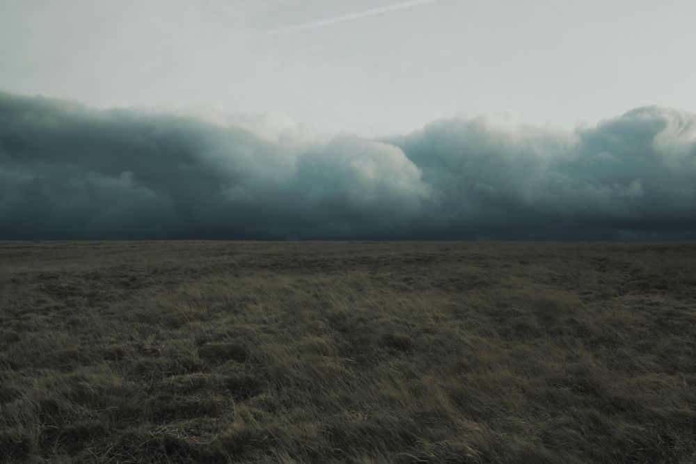The flat high plateau of north Dartmoor. A large bank of rain clouds sits across the horizon.
