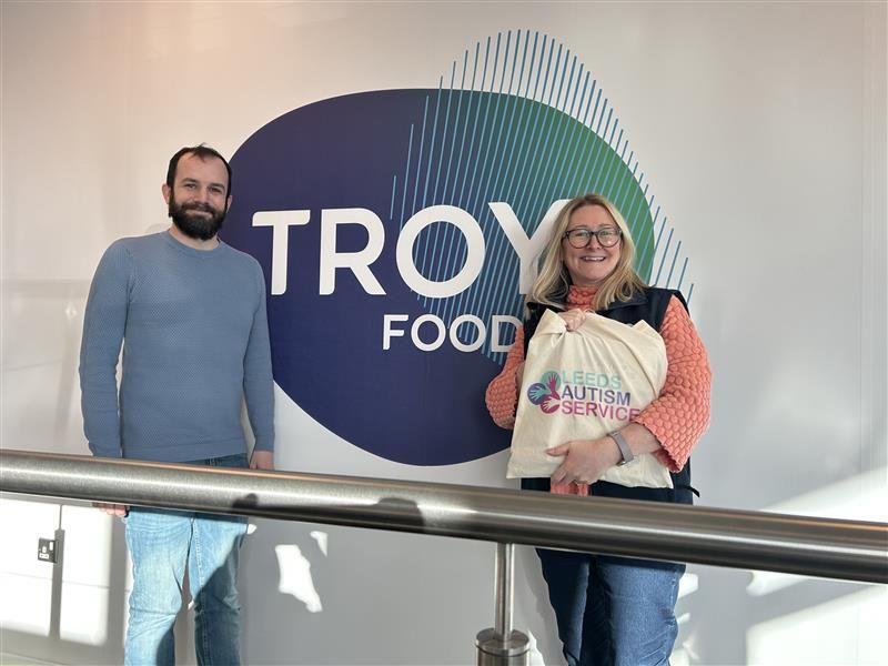 Tom and Jo in front of the Troy Foods logo