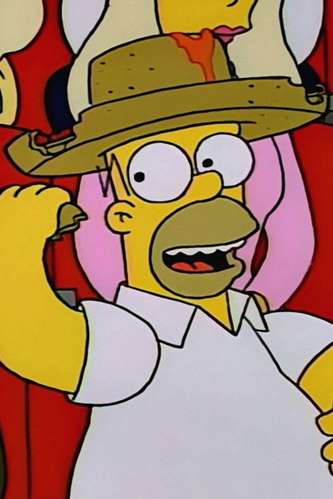 Homer wearing his nacho sombrero while attending a football game with Ned Flanders 