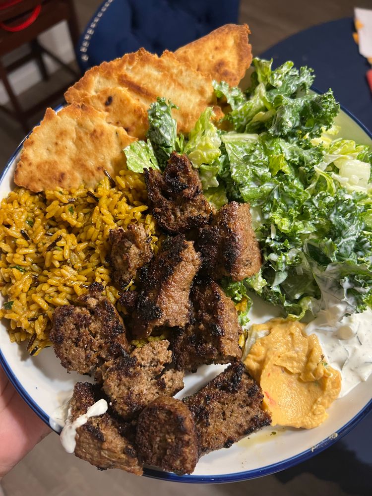 halal cart inspired plate. grilled lamb over rice, leafy green salad with pita bread and lil dollops of tzatziki sauce and roasted red pepper hummus. 