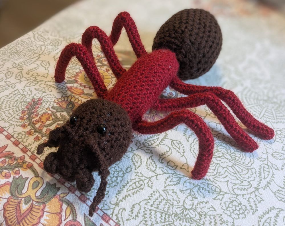 crochet ant in red and brown yarn