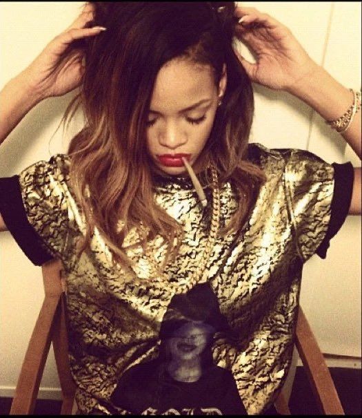 Rhianna looking frustrated with her hands in hair and wearing a gold colored shirt.