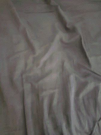 a close up of a person laying on a bed covered in sheets