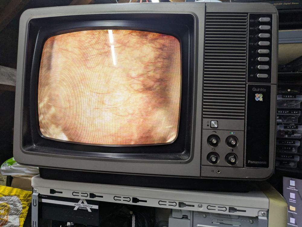 Oh God! Do you really want to know? Ok, it's a close up of a man's nutsack being played from a VHS tape and shown on a late 70s Panasonic TV. I believe it's from "The World of the Unborn" a documentary about where babies come from.