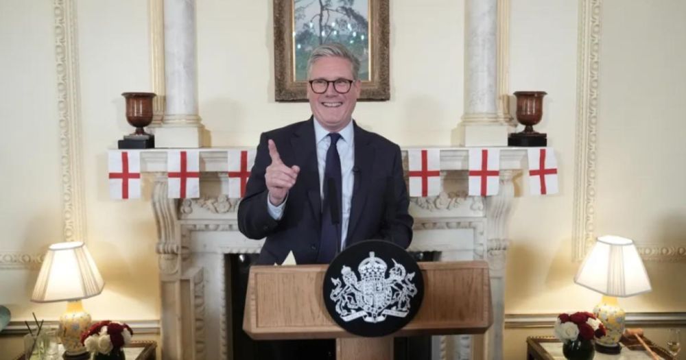 Sir Keir Starmer at Downing Street podium, with a string of St George's Cross flags behind him.