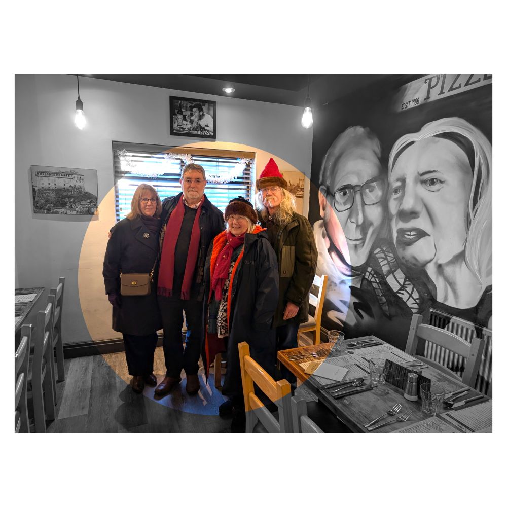 Disgrifiad (Cymraeg) : Pedwar o bobl mewn pizzeria gyda murlun yn y cefndir.Mae'r bobl mewn lliw mewn cylch, mae gweddill y ddelwedd yn unlliw.

Description (English) : Four people in a pizzeria with a mural in the background. The people are in colour in a circle, the rest of the image is monochrome.

འགྲེལ་བཤད།(བོད་ཡིག) : མཛའ་བཤེས་་ (mDza’ bShes) Friend
