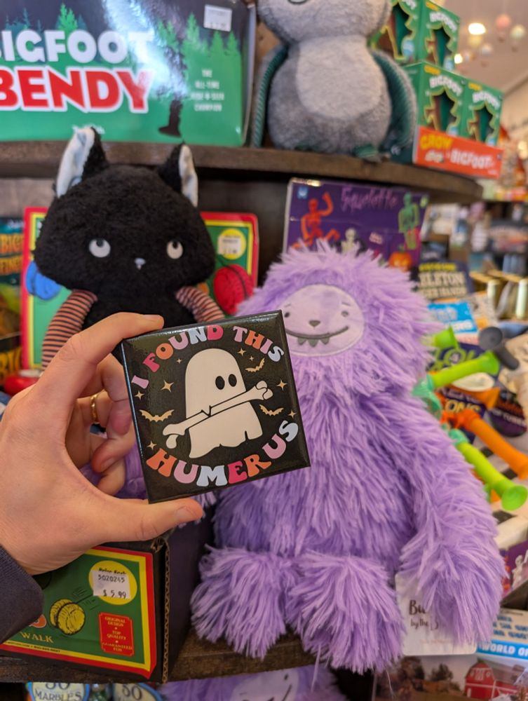 Toy store milieu, featuring ghost holding a bone, reads “I found this humerus.”