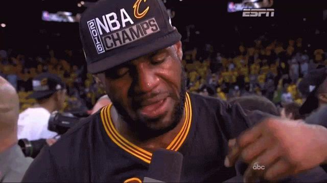 a man wearing a hat that says nba champs is crying