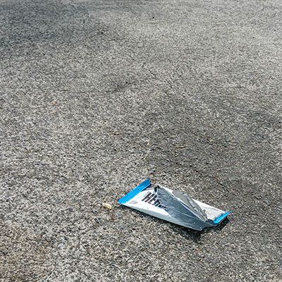 a discarded candy wrapper on a swath of pavement