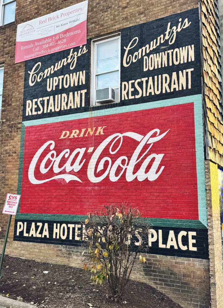 A mural featuring an advertisement for Coca Cola and Comuntzis Uptown Restaurant in Morgantown, WV