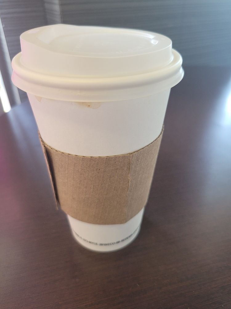 Vaso de cartón de café, sobre una mesa