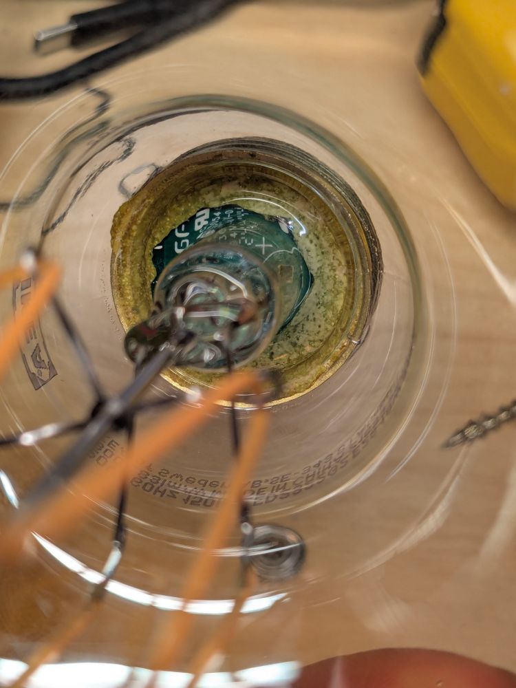 Quite a bit of glue seems to be visible in the base of the lamp, between the glass, metal shell, and PCB