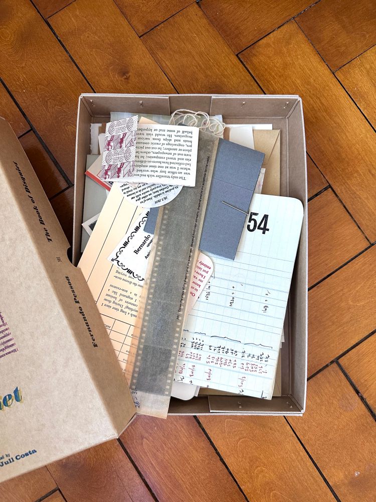 The box opened. Inside are objects and documents and scraps of things, the ephemera of a life, each printed with one of the fragments of text that make up The Book of Disquiet. 