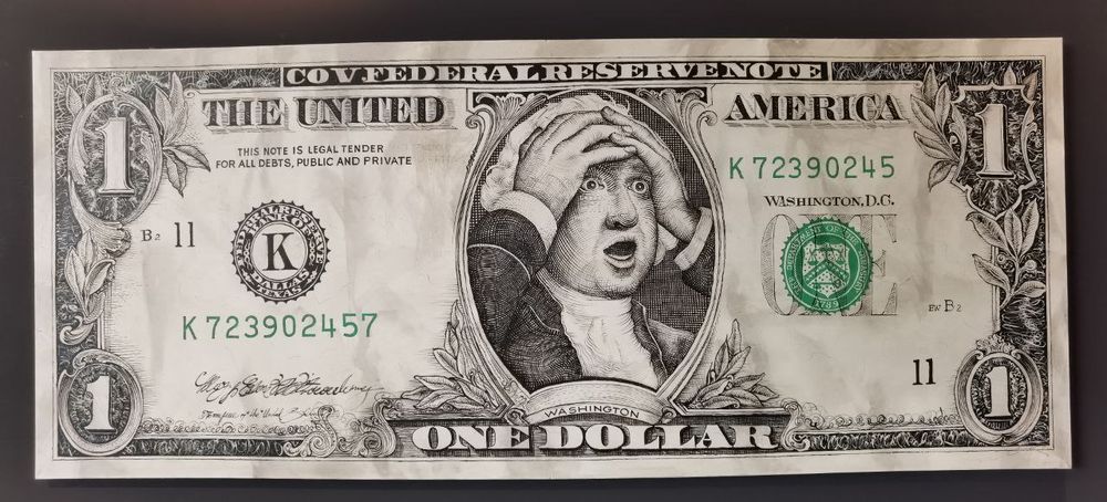 Ausstellungsstück auf der Nordart. Eine Dollarnote, auf der George Washington die Hände über dem Kopf zusammenschlägt und einen schockierten Gesichtsausdruck hat.
